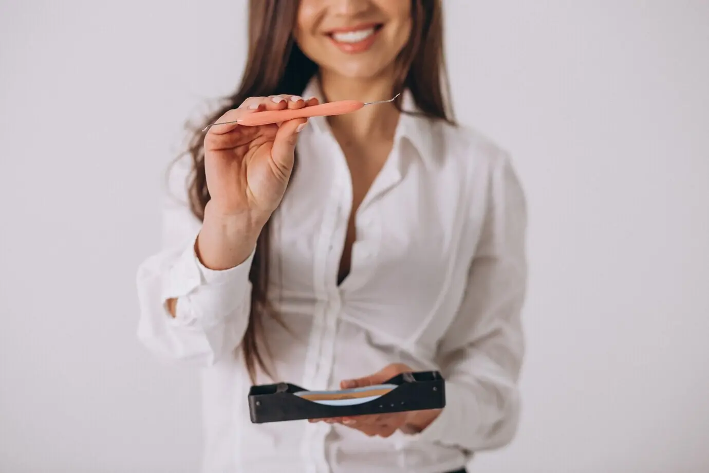 Женщина-стоматолог со стоматологическими инструментами, на изолированном фоне