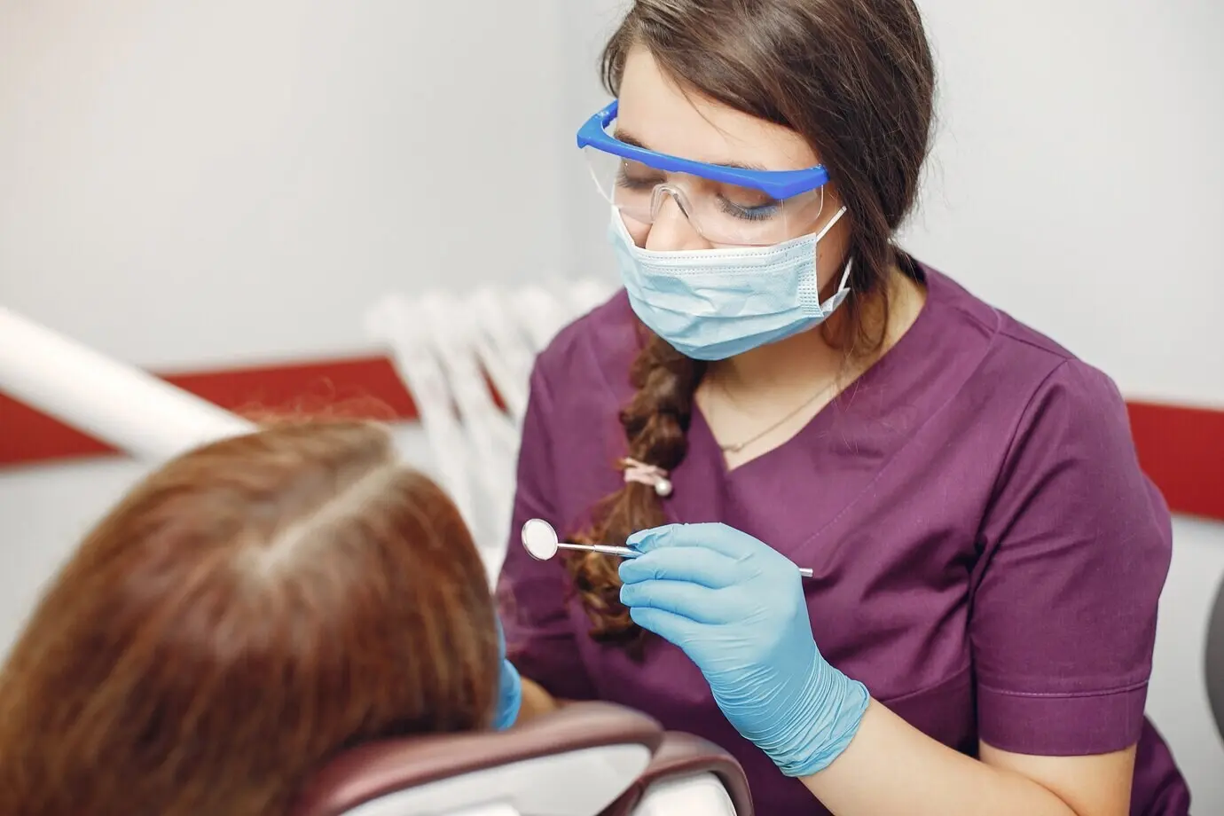 Красивая девушка сидит в кабинете стоматолога.